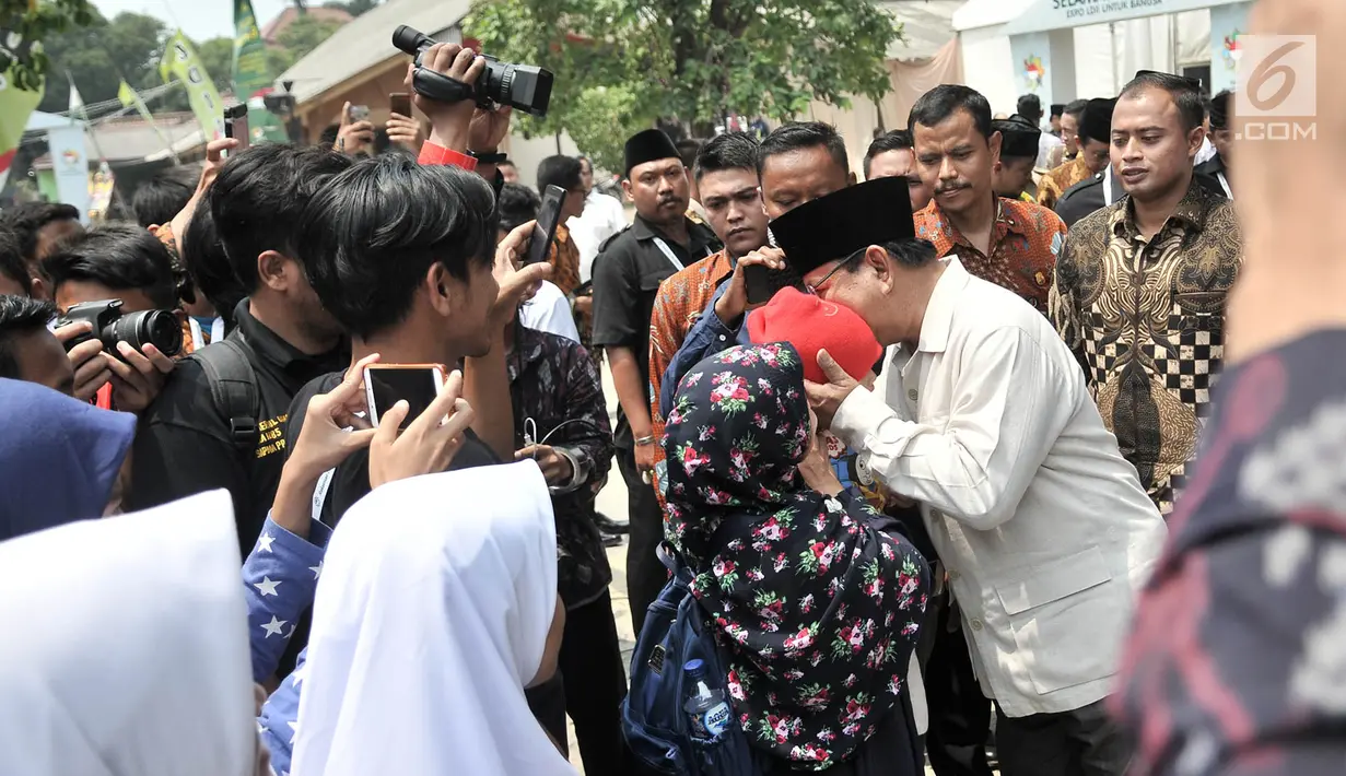 Calon presiden nomor urut 02 Prabowo Subianto mencium seorang anak saat menghadiri Rakernas LDII di Pondok Gede, Jakarta, Kamis (11/10). Prabowo datang dengan mengenekan kemeja safari cokelat dan peci hitam. (Merdeka.com/Iqbal Nugroho)