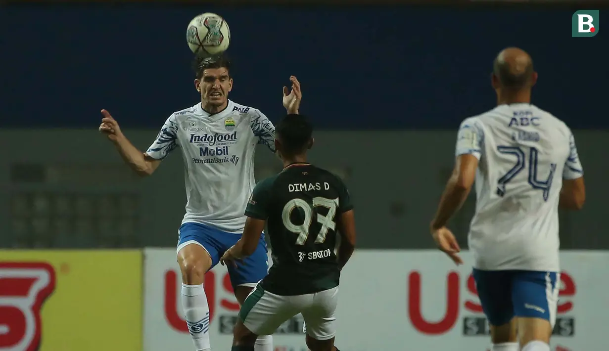 Pemain Persib Bandung, Nick Kuipers (kiri) mengontrol bola di udara dibayangi pemain Persikabo 1973, Dimas Drajad dalam laga pekan ke-5 BRI Liga 1 2021/2022 di Stadion Wibawa Mukti, Cikarang, Senin (27/9/2021). Kedua tim bermain imbang 0-0. (Bola.com/Ikhw