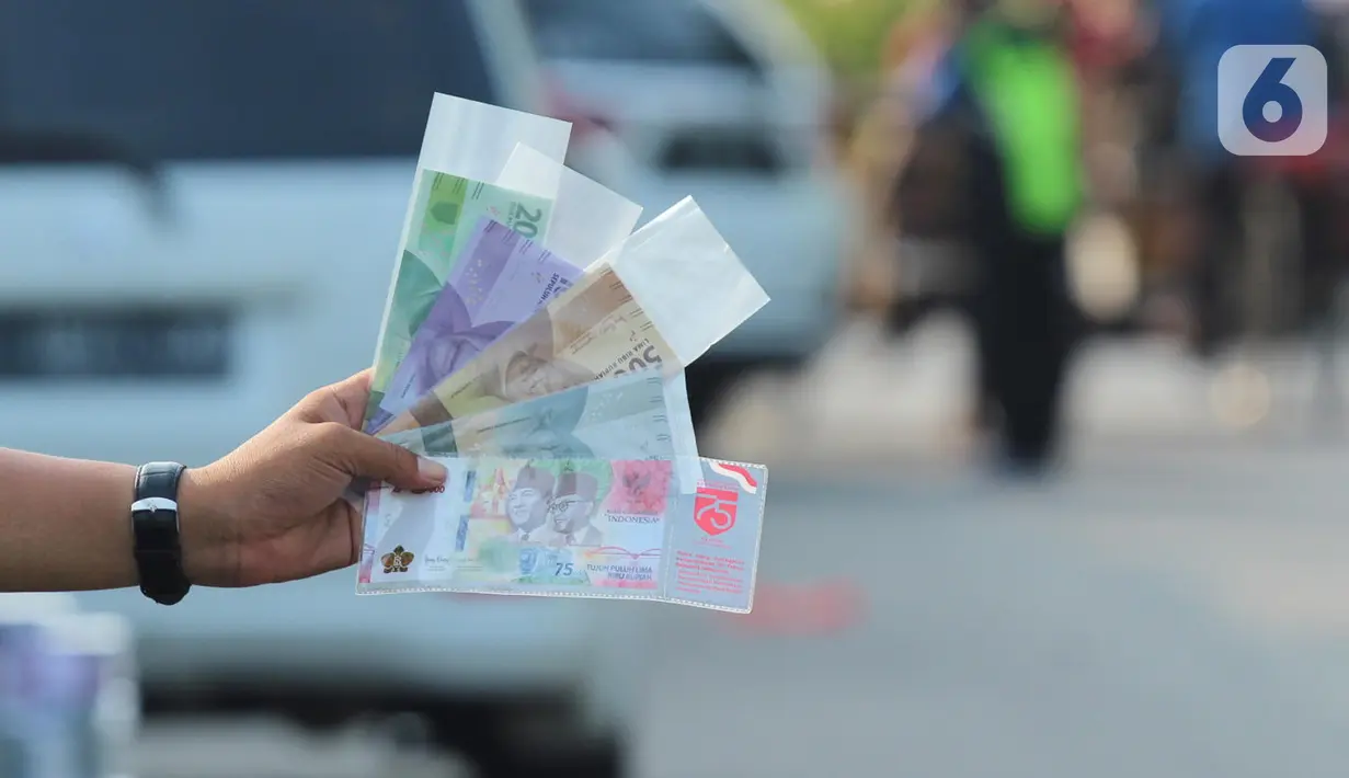 Penjual jasa penukaran uang pecahan menunggu konsumen di Jalan Otista Raya di Karawaci, Kota Tangerang, Senin (10/5/2021). Penjual jasa penukaran uang baru musiman tersebut mulai bermunculan menjelang lebaran yang dikenakan tarif jasa sebesar 10 persen. (Liputan6.com/Angga Yuniar)
