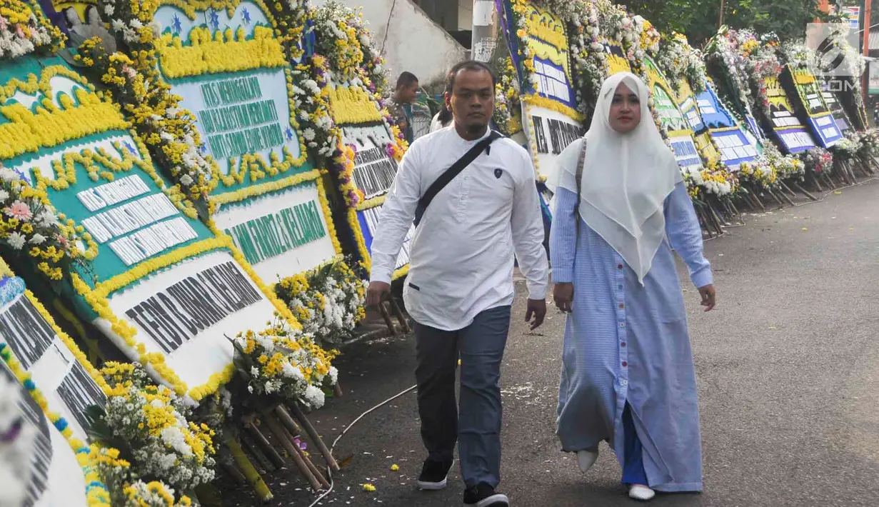 Warga berjalan di sekitar tempat persemayaman Ani Yudhoyono di Puri Cikeas, Bogor, Jawa Barat, Minggu (2/6/2019). Ani Yudhoyono akan dimakamkan di TMP Kalibata pada pukul 15.00 WIB.(Liputan6.com/Immanuel Antonius)
