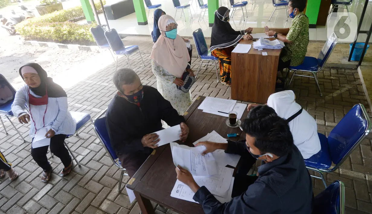 Petugas mengecek data warga Desa Curug sebelum menyerahkan Bantuan Langsung Tunai Dana Desa (BLT-DD) di Kantor Desa Curug, Kabupaten Bogor, Jawa Barat, Kamis (17/09/2020). Bantuan tersebut diberikan kepada 155 per KK untuk bisa mengurangi akibat terdampak COVID-19. (merdeka.com/Dwi Narwoko)