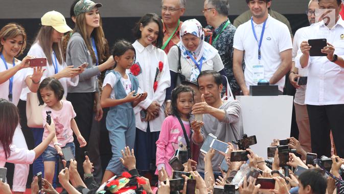 Presiden Joko Widodo (tengah) berswafoto usai peresmian pengoperasian Moda Raya Terpadu Jakarta fase 1 di kawasan Bundaran HI, Jakarta, Minggu (24/3). Acara ini sekaligus pencanangan pembangunan Moda Raya Terpadu Jakarta fase 2. (Liputan6.com/Helmi Fithriansyah)