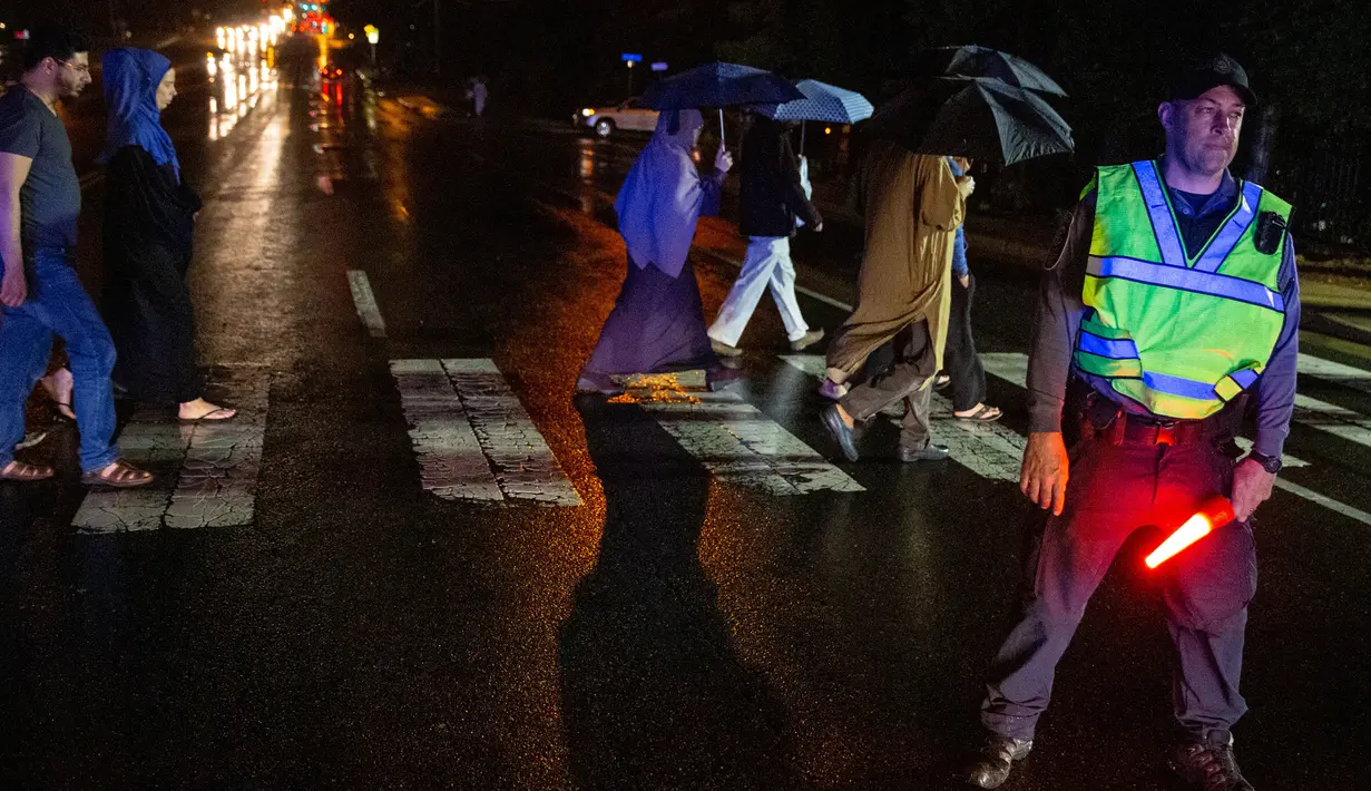 Polisi berjaga-jaga saat umat muslim ingin melaksanakan salat tarawih di Dar Al Hijrah Islamic Center, Falls Church, Virginia, Amerika Serikat, 11 Mei 2019. Selain umat muslim, datangnya bulan suci Ramadan disambut antusias oleh warga AS lainnya dengan ikut berpartisipasi. (REUTERS/Amr Alfiky)