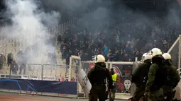 Kepulan asap flare terlihat sebelum pertandingan Liga Champions antara Ajax Amsterdam melawan AEK Athena di Stadion Olimpiade Athena, Selasa (27/11). Suporter tuan rumah melempar flare dan bom molotov ke arah tribun suporter Ajax. (AP/Thanassis Stavrakis)