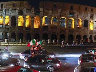 Suporter merayakan kemenangan Italia atas Inggris pada pertandingan final Euro 2020 di depan Colosseum, Roma, Italia, Senin (12/7/2021). Italia menjuarai Euro 2020 usai mengalahkan Inggris lewat drama adu penalti pada pertandingan final Euro 2020. (AP Photo/Riccardo De Luca)