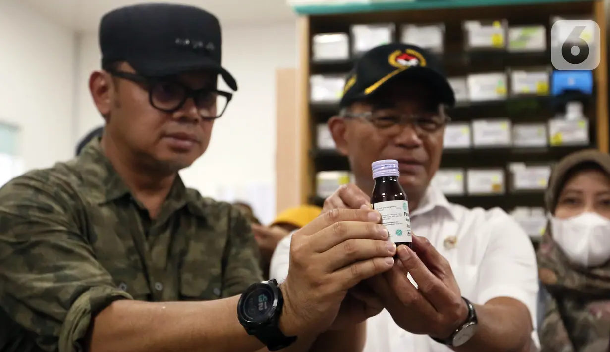 Menteri Koordinator Bidang Pembangunan Manusia dan Kebudayaan (Menko PMK) Muhadjir Effendy (kanan) bersama Wali Kota Bogor Bima Arya (kiri) menunjukkan obat sirup penurun panas anak yang dilarang penggunaannya saat sidak di Depo Farmasi Poliklinik Afiat RS PMI, Bogor, Jawa Barat, Sabtu (22/10/2022). Sidak dilakukan pada depo farmasi dan dua apotek di Kota Bogor menyusul terbitnya surat edaran nomor SR.01.05/III/3461/2022 dari Kementerian Kesehatan tentang penghentian sementara penggunaan obat dan vitamin dalam bentuk cair atau sirup kepada anak-anak. (merdeka.com/Arie Basuki)