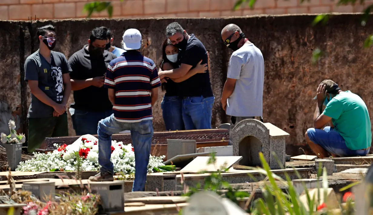 Anggota keluarga menghadiri pemakaman Elvira Maria de Jesus (75), yang dikatakan meninggal karena COVID-19, di pemakaman Campo da Esperanca di Brasilia, Brasil, Kamis (3//9/2020). Brasil melaporkan rata-rata lebih dari 1.000 kematian setiap hari akibat corona sejak akhir Mei. (AP Photo/Eraldo Peres)
