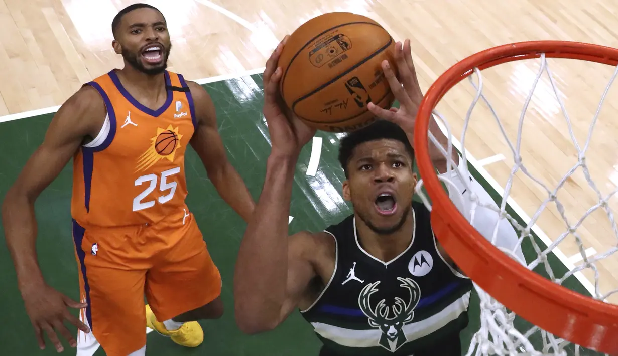 Pebasket Milwaukee Bucks Giannis Antetokounmpo (34) berusaha memasukan bola dari kawalan pebasket Phoenix Suns, Mikal Bridges (25) pada Game 6 Final NBA bola basket di Milwaukee, Selasa (20/7/2021). Bucks menang 105-98. (AP Photo/Aaron Gash)