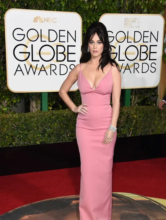 Katy Perry mengenakan gaun merah muda dengan belahan sangat rendah yang mengekspose belahan dadanya. Ia bahkan bercanda jika ia membawa ‘globes’ (bola)-nya sendiri di acara Golden Globe Awards 2016 ini. (AFP/Bintang.com)
