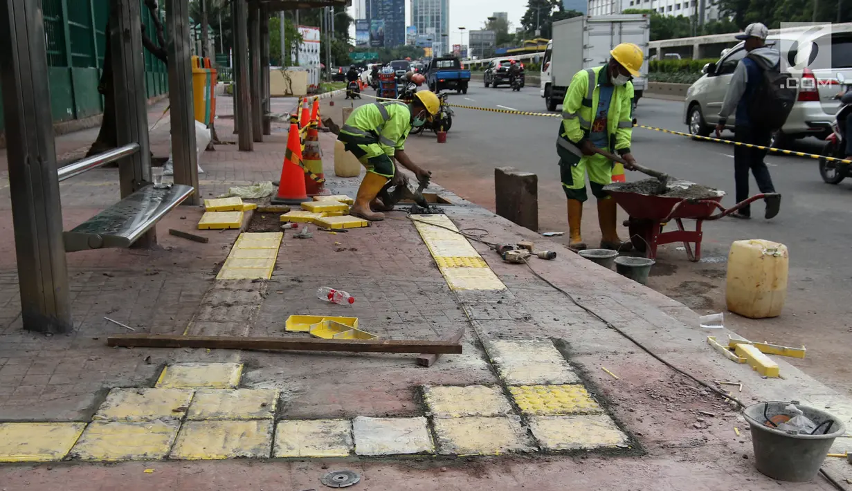 Pekerja memasang jalur khusus tunanetra dalam penataan jalur pedestrian di Jalan Gatot Subroto, Jakarta, Selasa (13/3). Pemprov DKI menata pedestrian untuk memberi kenyamanan dan keamanan bagi pejalan kaki. (Liputan6.com/Arya Manggala)