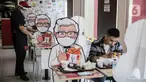 Pelayan merapikan banner bergambar karakter di KFC Salemba, Jakarta, Selasa (23/6/2020). Banner bergambar tersebut berguna untuk pembatas bagi pengunjung yang makan di tempat saat fase kenormalan baru. (Liputan6.com/Faizal Fanani)