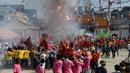 Sejumlah warga menyalakan petasan saat merayakan festival keagamaan tahunan untuk Dewi yang sangat dihormati dari Kuil Chao Mae To Mo di distrik Sungai Kolok, Thailand (8/5). (AFP/Madaree Tohlala)