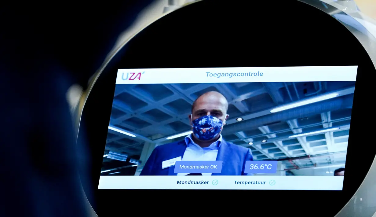 Seorang karyawan perusahaan Belgia, ZoraBots, menguji robot yang disebut CRUZR di Antwerp University Hospital (UZA) pada 29 Mei 2020. Robot ini dapat mendeteksi demam serta mengetahui pengunjung rumah sakit  yang memakai Masker atau tidak. (Kenzo TRIBOUILLARD/AFP)