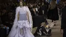 Seorang pengunjuk rasa dikeluarkan dari runway peragaan busana Louis Vuitton Spring/Summer 2022 di Paris, Selasa (5/10/2021). Membentangkan spanduk, pengunjuk rasa itu berbaris di jalan yang sama dengan para model. (Vianney Le Caer/Invision/AP)