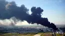 Gumpalan asap membubung dari kebakaran tempat penyimpanan bahan petrokimia di Intercontinental Terminals Co (ITC) di Deer Park, Texas, Senin (18/3). Kebakaran mengirimkan asap hitam tebal ke udara hingga sejauh bermil-mil. (AP/David J. Phillip)