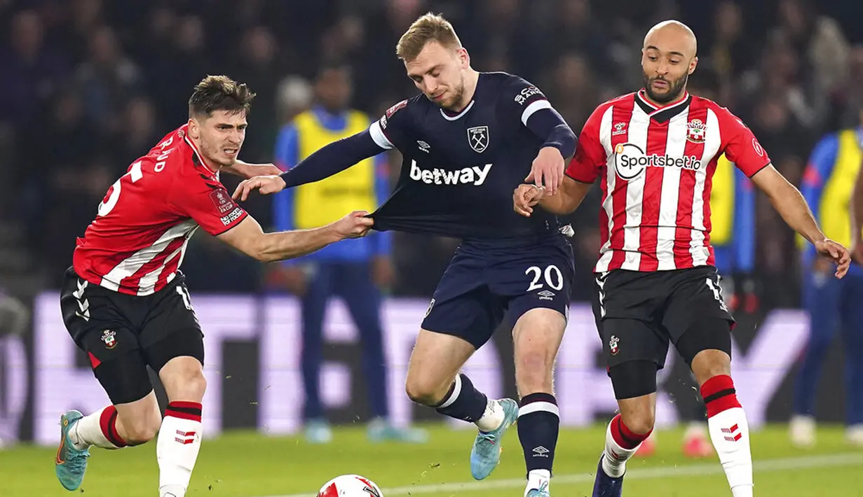 Pemain West Ham Jarrod Bowen (tengah) berebut bola dengan pemain Southampton Romain Perraud (kiri) dan Nathan Redmond pada pertandingan sepak bola putaran kelima Piala FA di Stadion St Mary, Southampton, Inggris, 2 Maret 2022. Southampton menang 3-1. (Adam Davy/PA via AP)