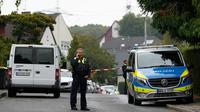 Seorang petugas polisi tampak berbicara di telepon di sebuah jalan di Herdecke, Jerman, pada Selasa (7/10/2025), setelah wali kota terpilih Herdecke, Iris Stalzer, ditemukan dalam kondisi kritis di apartemennya.(Dok. AP/Martin Meissner)