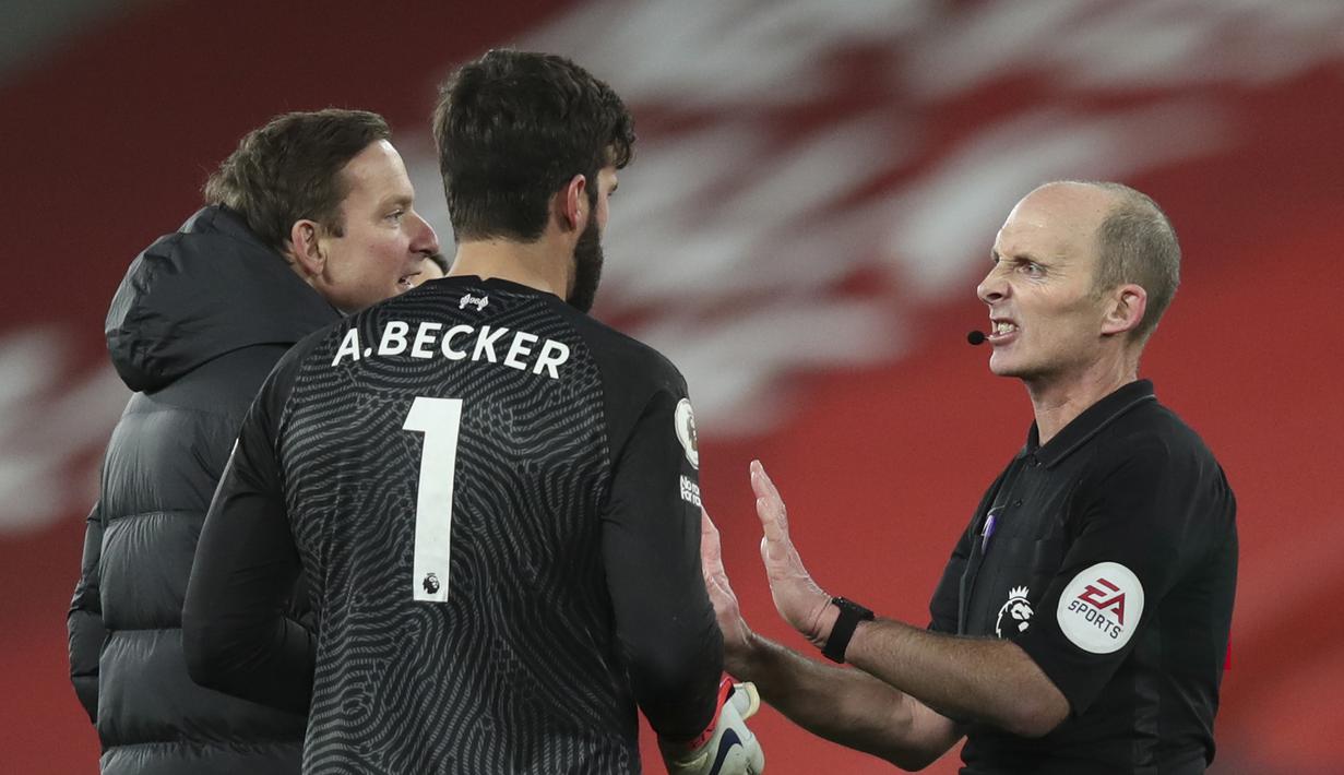 Kiper Liverpool, Alisson Becker (tengah) berdebat dengan wasit Mike Dean usai berakhirnya laga lanjutan Liga Inggris 2020/21 melawan Burnley di Anfield Stadium, Liverpool, Kamis (21/1/2021). Liverpool kalah 0-1 dari Burnley. (AFP/Clive Brunskill/Pool)