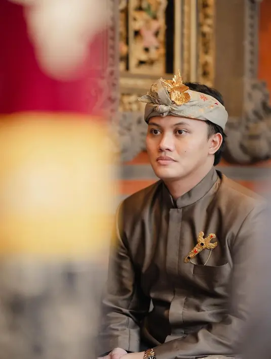 Calon pengantin Rizky Febian tampil mangling dengan gagah dengan baju adat Bali untuk pria. Atasan cokelat yang berkilauan dipadu dengan kain Bali yang khusus, serta udengnya. [Foto: Instagram/mahaliniraharja]