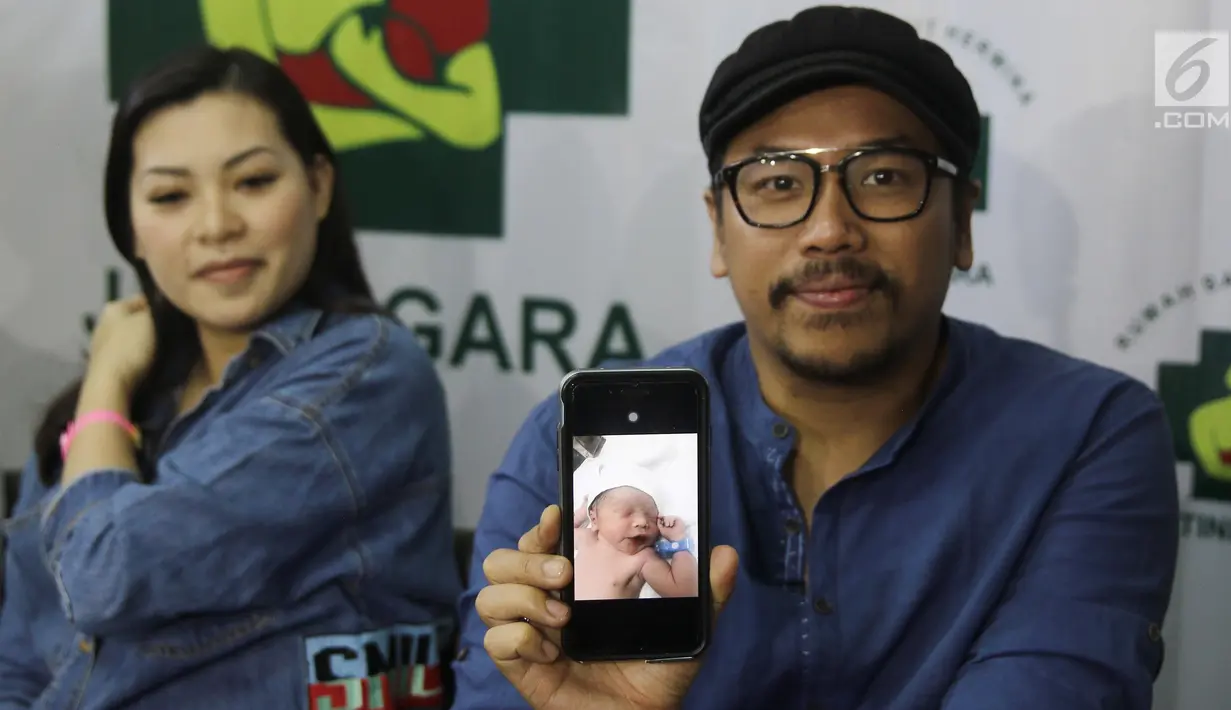 Sammy Simorangkir dan Viviane menunjukkan foto anak pertama mereka saat jumpa pers di rumah sakit kawasan Jatinegara, Jakarta, Jumat (24/8). Sammy dan Viviane dikaruniai anak laki-laki. (Liputan6.com/Herman Zakharia)