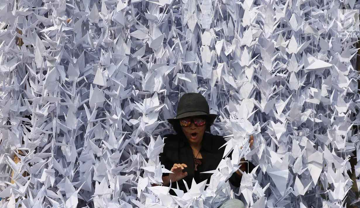 Warga berada di tengah-tengah burung origami di halaman depan Balai Kota, Jakarta, Sabtu (27/5). Seribu Origami Burung Perdamaian imi merupakan aksi atau gerakan spontanitas atas dasar kecintaan kepada NKRI. (Liputan6.com/Angga Yuniar)