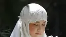 Gaya hijab yang dikenakan Annisa Pohan dalam foto ini adalah model mukena berwarna putih polos dengan desain sederhana namun elegan. Mukena ini memiliki potongan yang longgar dan nyaman, dengan aksen renda di bagian bawah yang menambah kesan anggun. (Liputan6.com/IG/@annisayudhoyono)