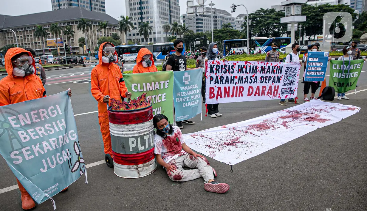 Sejumlah aktivis melakukan teatrikal dengan menyiramkan darah di tubuhnya saat aksi serentak desak Presiden Jokowi deklarasikan Darurat Iklim di kawasan Patung Kuda, Jakarta, Jumat (19/3/2021). Aksi serentak di beberapa lokasi itu untuk menuntut deklarasi darurat iklim. (Liputan6.com/Faizal Fanani)