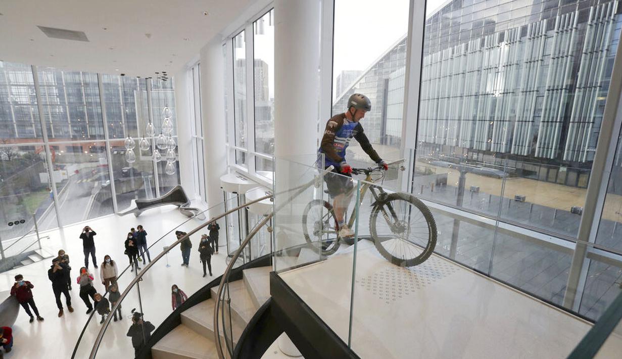 Pembalap sepeda asal Prancis, Aurelien Fontenoy, saat mendaki 768 anak tangga dari 33 lantai gedung Trinity Tower di distrik La Defense, Paris, (17/1/2021). (AP/Christophe Ena)