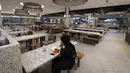 Seorang pekerja makan siang di food court yang kosong di sebuah pusat perbelanjaan, Kuala Lumpur, Malaysia, Kamis (14/1/2021). Otoritas Malaysia memperketat pembatasan pergerakan untuk mencoba menghentikan penyebaran virus corona COVID-19. (AP Photo/Vincent Thian)