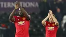 Pemain Manchester United, Romelu Lukaku dan Daley Blind memberikan apalus usai melawan Swansea City pada laga Piala Liga Inggris di Stadion Liberty, Swansea, Selasa (24/10/2017). Manchester United menang 2-0 atas Swansea City. (AFP/Geoff Caddick)