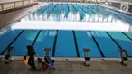 Petugas kebersihan berjalan dekat kolam Stadion Akuatik Gelora Bung Karno (GBK), Jakarta, Rabu (11/7). Stadion ini memiliki 3 kolam utama dan 1 kolam pemanasan berstandar Olimpiade dari FINA (Federasi Renang Internasional). (Liputan6.com/Faizal Fanani)