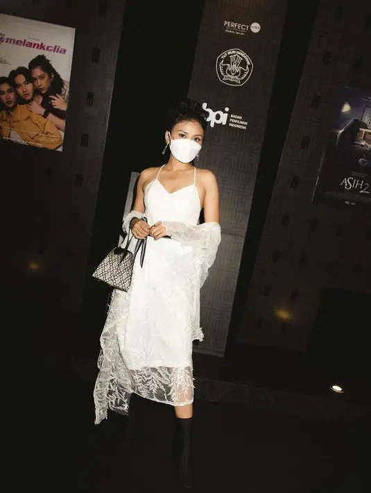 Hadiri festival film Indonesia 2020, Dea terlihat cantik kenakan dress warna putih dengan syal aksen brokat. Sepatu boots yang dikenakan membuat penampilannya semakin standout.(Instagram/deapanendra).