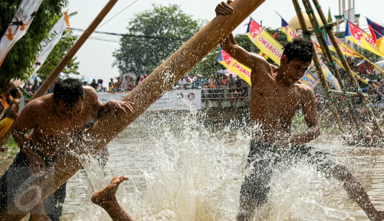 Warga berusaha memanjat saat mengikuti lomba panjat pinang dalam rangka merayakan HUT RI ke-70 di Bantaran Kalimalang, Jakarta, Senin(17/8/2015). Warga antusias mengikut lomba panjat pinang tersebut. (Liputan6.com/Yoppy Renato)