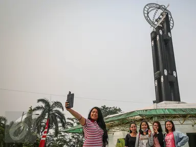 Wisatawan berfoto di depan Tugu Khatulistiwa, Pontianak, Kalimantan Barat, 23 Agustus 2015. Ikon wisata kota Pontianak ini masih menjadi primadona wisata sejarah bagi wisatawan lokal maupun luar. (Liputan6.com/Faizal Fanani)