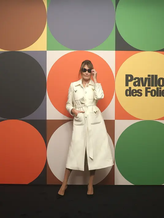 Sementara itu, model Italia dan Prancis Carla Bruni mengenakan mantel berhias warna putih dan emas serta menenteng tas bermotif bunga. [Dok/Valentino].