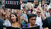 Sejumlah pendemo berorasi mengecam Donald Trump terkait larangan transgender masuk militer AS di Times Square, Rabu (26/7). Pemerintah belum memutuskan apakah transgender yang sudah bertugas di militer akan dikeluarkan atau tidak. (AP/Frank Franklin II)