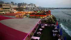 Keluarga Palestina menikmati makanan di sebuah restoran di sepanjang pantai di Kota Gaza (10/6/2019). Pergi ke restoran di dekat pantai merupakan opsi bagi warga Palestina untuk menikmati suasana alam. (AFP Photo/Mohammed Abed)