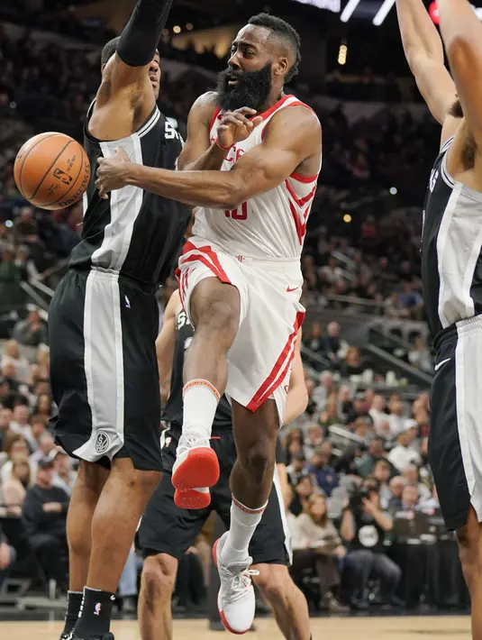 Aksi pemain Houston Rockets, James Harden memberikan umpan melewati adangan dua pemain Spurs pada lanjutan NBA basketball game di AT&T Center, San Antonio, (1/02/2018). Houston menang 102-91. (AP/Darren Abate)