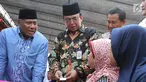 Ketua Komisi VIII DPR, M Ali Taher, didampingi Dirjen Perlindungan dan Jaminan Sosial, Harry Hikmat berbincang dengan warga saat proses pencairan dana Program Keluarga Harapan (PKH) di Desa Cikuya Kabupaten Tanggerang, Jumat (28/9). (Liputan6.com/HO/Agus)
