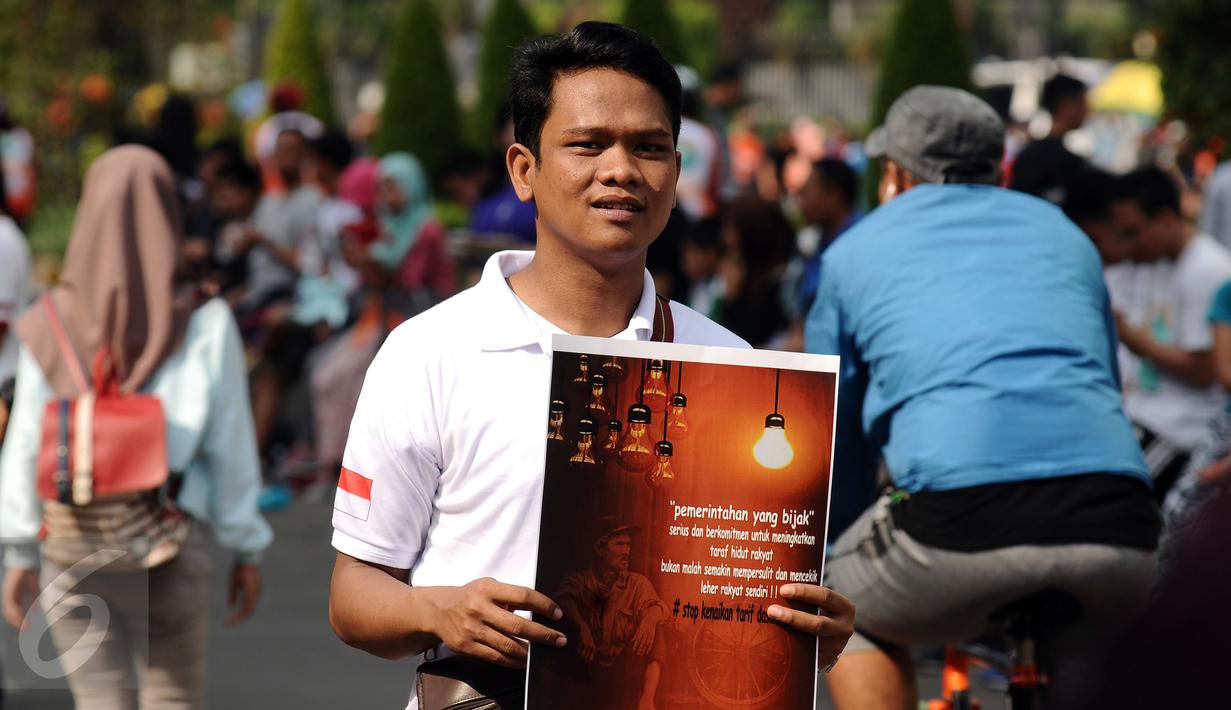 Salah satu peserta aksi mengkampanyekan Petisi Penolakan Kenaikan Tarif Dasar Listrik di kawasan Bundaran HI, Jakarta, Minggu (7/5). Mereka meminta pihak berwenang mengkaji kembali kebijakan kenaikan tarif dasar listrik. (Liputan6.com/Helmi Fithriansyah)
