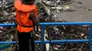 Petugas memilah sampah yang menumpuk di Pintu Air Manggarai, Jakarta, Rabu (24/4). Tingginya curah hujan di Bogor membuat sampah yang berasal kebanyakan dari sampah rumah tangga ini terbawa arus sungai menumpuk di Pintu Air Manggarai. (Liputan6.com/Johan Tallo)