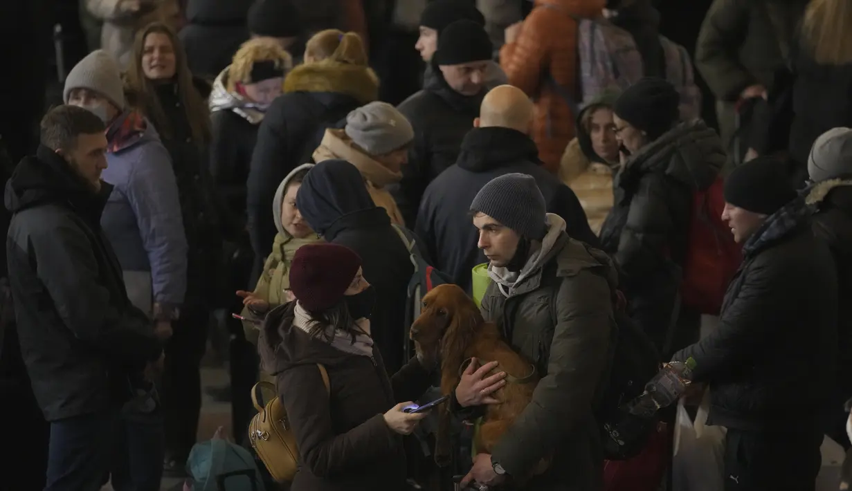 Pasangan berbicara setelah orang-orang bergegas naik kereta menuju Lviv di Kiev, Ukraina, 28 Februari 2022. Dalam eksodus lebih dari 2,5 juta orang yang melarikan diri dari invasi Rusia, terdapat hewan peliharaan yang tidak dapat ditinggalkan. (AP Photo/Vadim Ghirda)