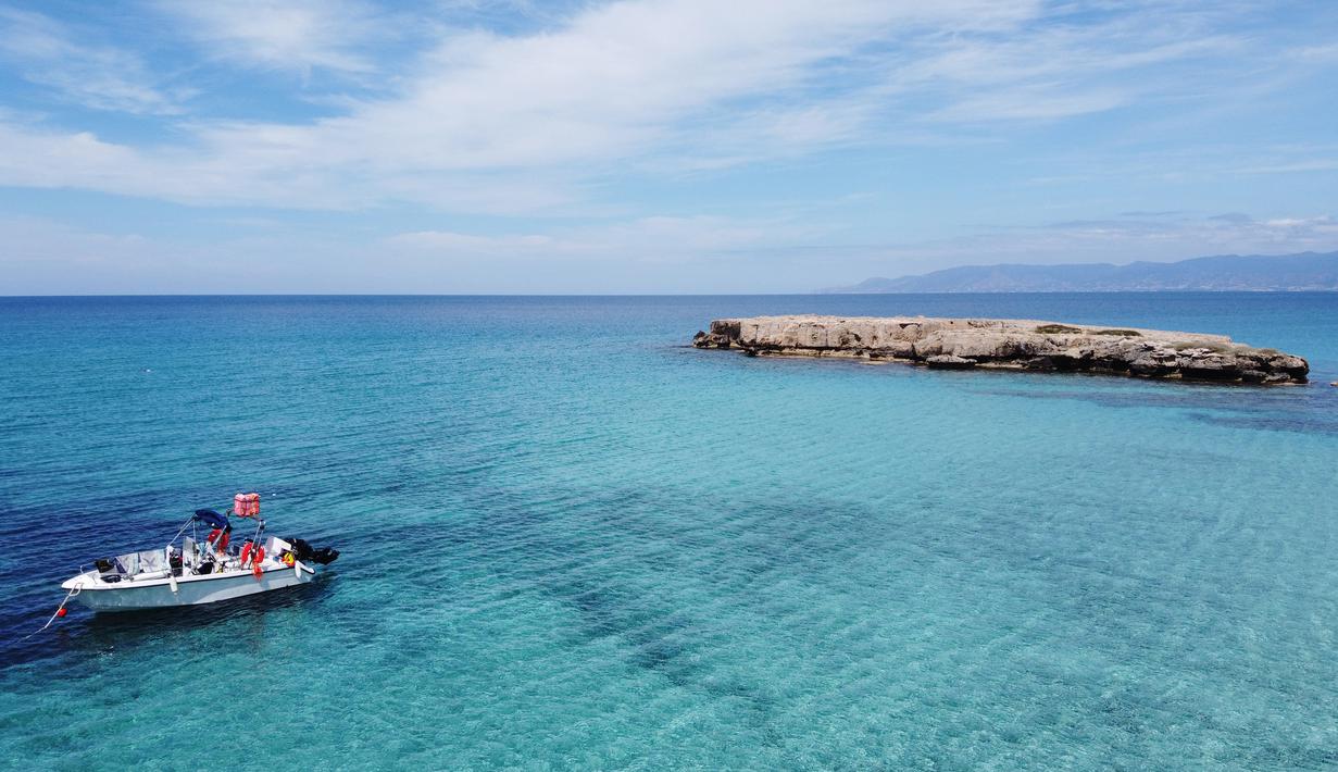 Sebuah perahu terlihat dari pemandangan udara di Akamas di sepanjang pantai barat Siprus (31/5/2020). Semenanjung ini dinamai setelah putra Theseus, pahlawan Perang Troya dan pendiri kerajaan kota Soli. (AFP Photo/Etienne Torbey)