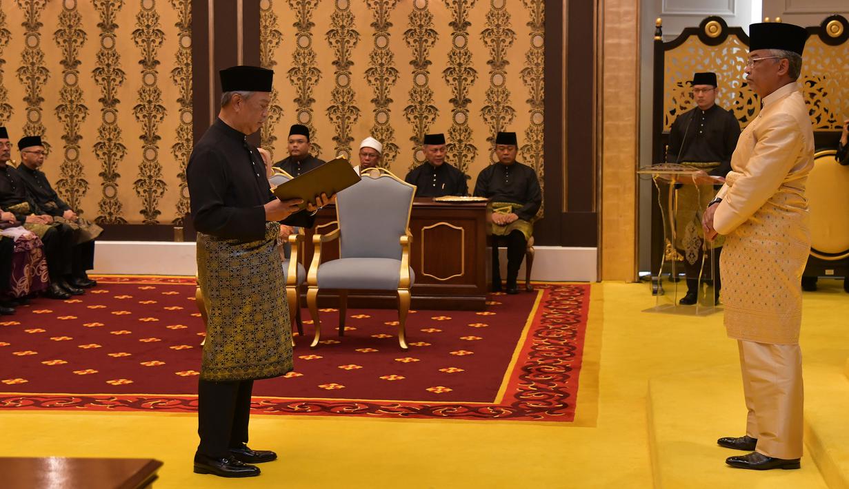 Muhyiddin Yassin (kiri) menyatakan sumpah di depan Raja Sultan Abdullah Sultan Ahmad Shah (kanan) saat upacara pelantikannya sebagai PM Malaysia, Istana Negara, Kuala Lumpur, Minggu (1/3/2020). Muhyiddin Yassin menjadi PM ke-8 Malaysia. (MASZUANDI ADNAN/MALAYSIA'S DEPARTMENT OF INFORMATION/AFP)