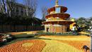 Seorang pria berjalan di dekat patung yang terbuat dari jeruk dan lemon menjelang festival Lemon di Menton, sebuah kota kecil di Perancis, Rabu (12/2/2015). (AFP PHOTO/Valery Hache)