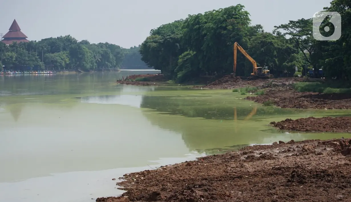 Petugas menggunakan alat berat untuk mengeruk lumpur di kawasan Setu Babakan, Jakarta, Rabu (21/10/2020). Program pengerukan lumpur kali, sungai, atau waduk di Jakarta bertujuan untuk mencegah banjir serta mengantisipasi adanya genangan air saat musim penghujan. (Liputan6.com/Immanuel Antonius)