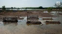 Pemakaman di Desa Pantai Bahagia terendam air, Muara Gembong, Kabupaten Bekasi, Jawa Barat, Jumat (9/6). Banjir rob sering terjadi di kawasan tersebut dengan ketinggian air mencapai 50 cm.(Liputan6.com/Gempur M Surya)