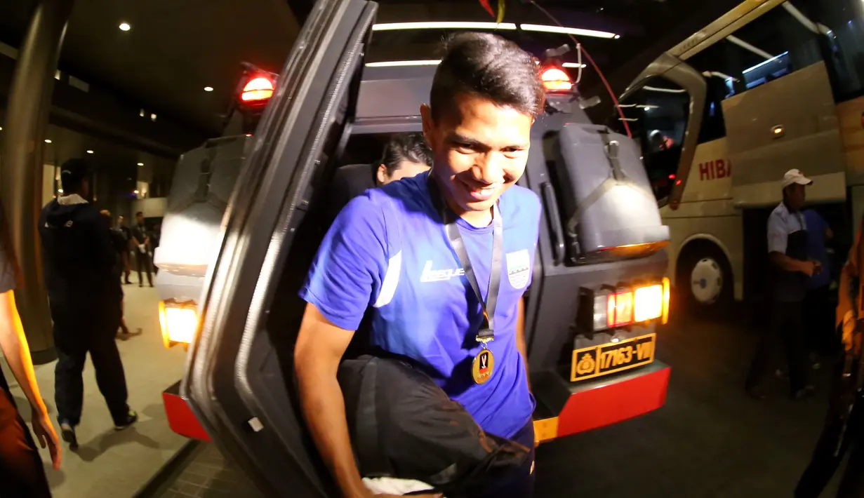 Pemain Persib, Ahmad Jufriyanto, turun dari kendaraan taktis (Rantis) polisi saat tiba di hotel setelah final Piala Presiden 2015 di Stadion Utama Gelora Bung Karno, Jakarta, Minggu (18/10/2015). (Bola.com/Nick Hanoatubun)