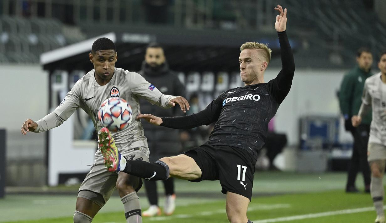 Striker Shakhtar Donetsk, Tete (kiri), berebut bola dengan bek Borussia Moenchengladbach, Oscar Wendt, dalam laga lanjutan Liga Champions 2020/21 Grup B di Moenchengladbach, Jerman, Kamis (26/11/2020). Shakhtar kalah 0-4 dari Gladbach. (AFP/Ina Fassbender)