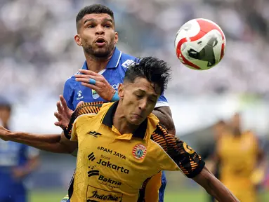 Pemain Persija Jakarta, Dony Tri Pamungkas (kanan) berebut bola dengan pemain Persib Bandung, Berguinho dalam laga lanjutan BRI Super League 2025/2026 di Stadion Gelora Bandung Lautan Api, Bandung, Minggu (11/01/2026). (Bola.com/Abdul Aziz)